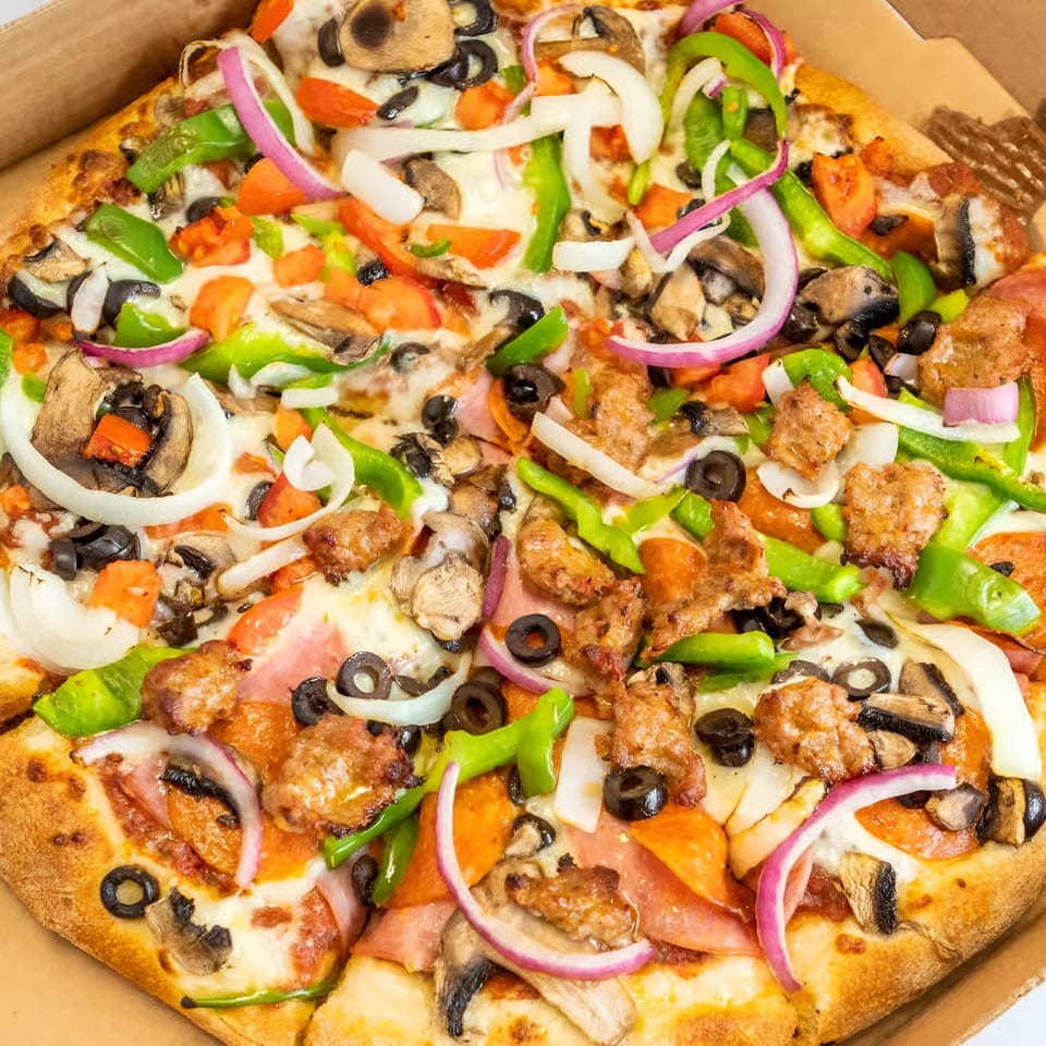 Antonious N&W Pizza's supreme pizza, loaded with sausage, pepperoni, ham, olives, onions, peppers, and mushrooms.