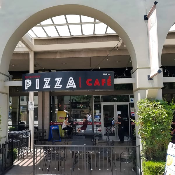 Antonious N&W Pizza Cafe storefront with outdoor seating, people, and a large "PIZZA CAFE" sign.